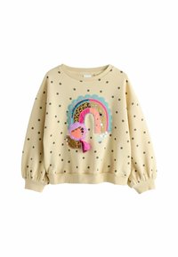Gul sweater med polkaprikker og ballonærmer, prydet med et farverigt regnbue-design, der inkluderer teksturer og palietter.
