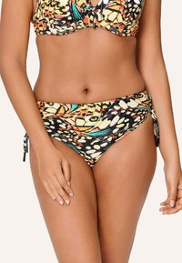 Conjunto de bikini con un patrón multicolor sobre fondo negro, laterales ajustables con lazos en la parte inferior y un diseño de top de sujetador que ofrece soporte.