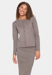 Grijze gebreide cardigan met lange mouwen, ronde halslijn en knoopsluitingen aan de voorkant. Gladde textuur, aansluitend ontwerp, bijpassende grijze rok.