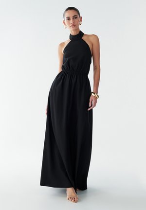 Abito maxi nero con scollatura a halter, vita cintrata e gonna fluida. Tessuto liscio con una leggera lucentezza. Design minimalista, senza fantasie né hardware.