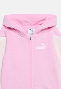 Ροζ ζακέτα με φερμουάρ για νήπιο, με κουκο ύλα, λευκό λογότυπο Puma στο στήθος και ετικέτα μεγέθους που δείχνει 12-18 μήνες.