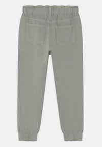 Light gray pants with an elastic waistband, featuring two back pockets and tapered cuffs at the ankles. Textured fabric with a smooth finish.