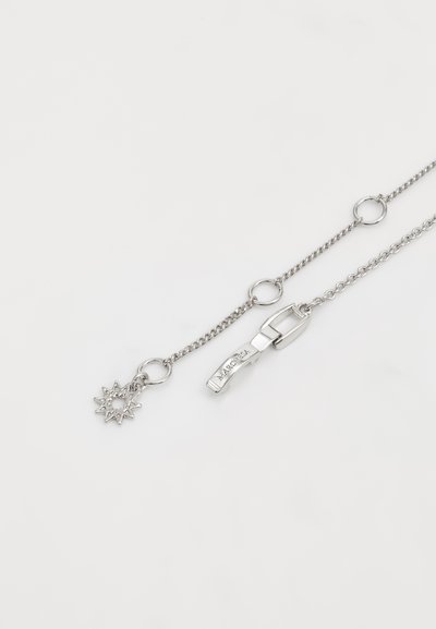 Collana in argento con charm a forma di sole e chiusura a moschettone. Presenta anelli circolari e un design strutturato.