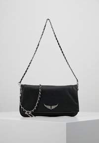 Bolso cruzado de cuero negro con una correa de cadena plateada, que presenta un emblema alado y cierre de cremallera, textura suave y forma rectangular.