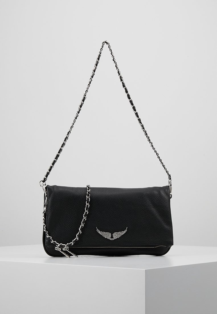 Bolso cruzado de cuero negro con una correa de cadena plateada, que presenta un emblema alado y cierre de cremallera, textura suave y forma rectangular.