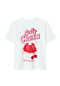 T-shirt en coton blanc avec un grand graphique rouge d'un dessert en gélatine avec des cerises, agrémenté du texte "Jelly Crush" au-dessus et d'un texte supplémentaire en dessous.