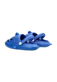 Zuecos de goma azul con punta redonda, con un diseño de ballena, acentos en blanco y una correa. Textura suave y detalles moldeados en la parte superior.