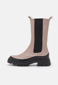 Beige leather ankle boot with a black elastic side panel, thick black rubber sole, and dual pull tabs at the top for easy wear.