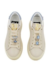 Sneaker in pelle beige con dettagli in tessuto blu, elementi decorativi simili a gemme sui lacci, punta rotonda e logo adesivo sulla linguetta interna.