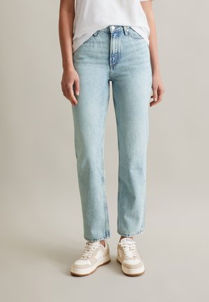 Light blue denim jeans with a straight cut, high waist, subtle fading, and a classic five-pocket design, paired with white sneakers.