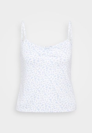 Bela majica na naramnice z lahkim modrim cvetličnim vzorcem, nastavljive tanke naramnice in mehak material; prilegajoč se kroj z okroglo izrezom.