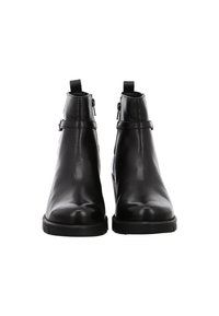 Pair of black leather ankle boots with side zippers, strap detail, pull tabs, and thick treaded soles, viewed from the front.