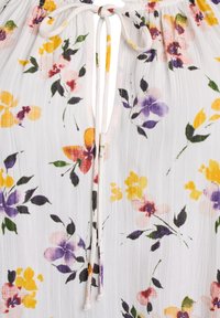 Tessuto leggero a motivo floreale bianco, con fiori gialli, viola e rosa. Include un dettaglio con coulisse nella scollatura.