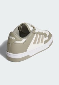 Grön och vit sneaker med överdel i texturerat läder, snörning, tre ränder på sidan och en vit gummisula.