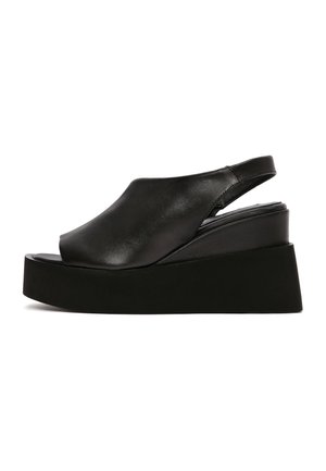 Sandalo zeppa in pelle nera con punta aperta, cinturino a slingback e suola piatta spessa.