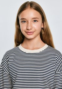 Dryžuota ilgomis rankovėmis viršutinė dalis tamsiai mėlynos ir grietinėlės spalvų, su apvaliu iškirpimu ir laisvu siluetu, pagaminta iš minkštos medvilnės audinio.