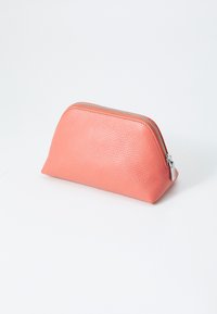 Pochette cosmetica in pelle rosa con finitura texturizzata, parte superiore arrotondata e cerniera argentata. Design compatto, adatto per oggetti piccoli.