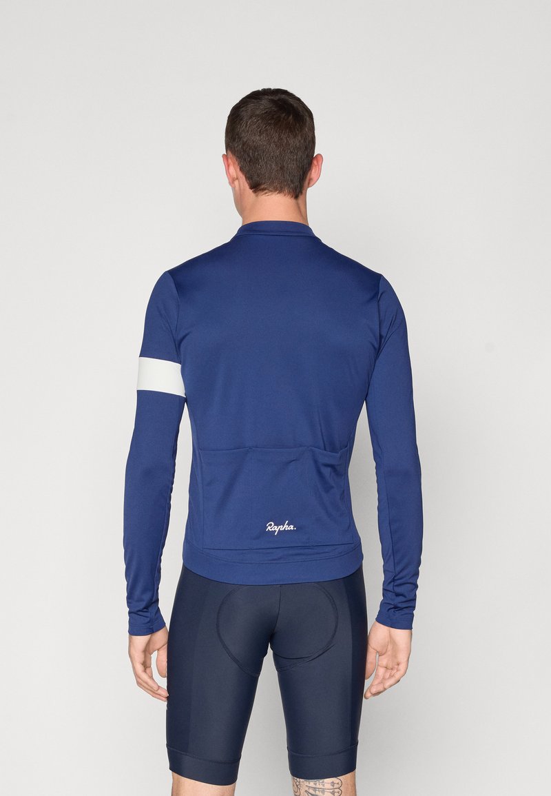 Mørkeblå langærmet cykeltrøje med hvid accent på armen, lavet af glat stof, med en baglomme og broderet logo detalje.