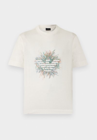 Λευκό T-shirt με κοντά μανίκια και πολύχρωμο, αφηρημένο σχέδιο με γραμμές που σχηματίζουν ένα στυλιζαρισμένο λογότυπο αετού στο κέντρο μπροστά.