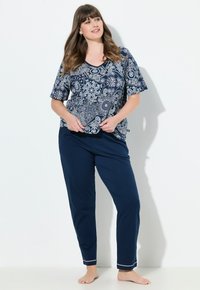 Mörkblått pyjamas-set bestående av en mönstrad kortärmad topp med v-ringning och matchande byxor med vita detaljer vid fållarna. Mjuk tygkvalitet.