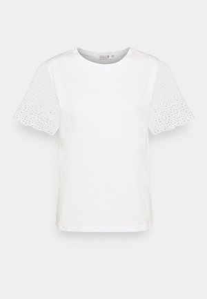 Blouse blanche à manches courtes avec encolure ronde et détails en dentelle ajourée sur les manches festonnées.