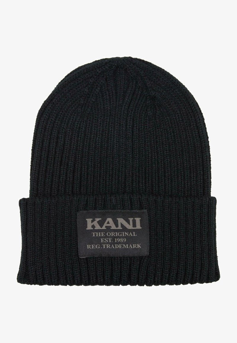 Černá pletená čepice s ohrnutým lemem, která má texturovaný vzor a obdélníkovou nášivku s nápisem "KANI THE ORIGINAL EST. 1989" v bílém písmu.