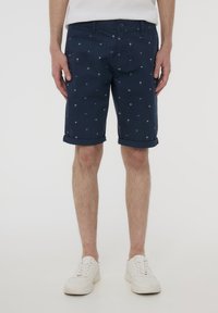 Pantaloni corti blu navy in misto cotone, con una stampa di piccoli palmi e triangoli, con orli arrotolati e chiusura con bottone.