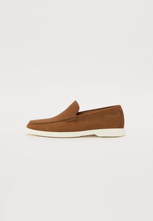 Brune læder loafers med et tekstureret mønster, hvid ydersål og minimalistisk design. Har en syet søm langs den øverste del.
