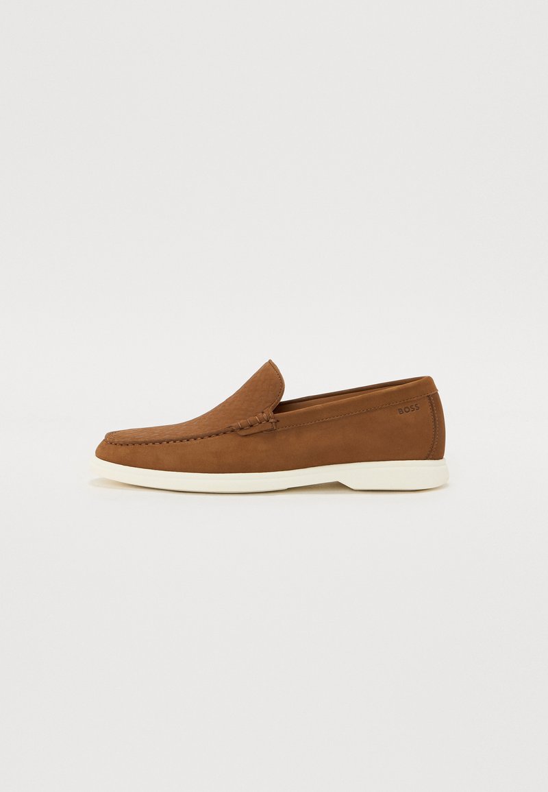 Loafere din piele maronie cu un model texturat, talpă exterioară albă și un design minimalist. Prezintă o cusătură pe partea superioară.