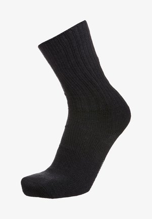 Calcetín negro de canalé con longitud hasta la mitad de la pantorrilla, con una textura suave y puntera reforzada. El tejido parece elástico y duradero.