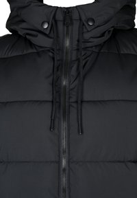 Svart puffjacka med dragkedja fram, robust hårdvara och fodrad huva. Har en quiltad design och justerbara snoddar.