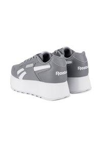 Šedé platformové tenisky Reebok s bielymi akcentmi a hrubými bielymi podrážkami, pohľad zozadu a mierne naklonené doľava.