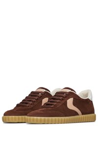 Sneaker in suede marrone con una superficie testurizzata, caratterizzati da un accento color crema, lacci rotondi e una suola in gomma con design rigato.