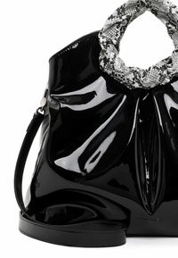 Sac à main en cuir verni noir avec une anse texturée au motif serpent noir et blanc. Il possède une finition lisse et brillante ainsi qu'une bandoulière réglable.