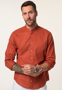 Rost-orange Langarmshirt, leichtes Material, Stehkragen, Vorderstasche, Knopfdesign, rollbare Ärmel, kontrastierende Knöpfe.