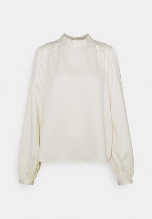 Cream-colored long-sleeve blouse with high neck, slight puffed shoulders, and buttoned cuffs on a plain background.