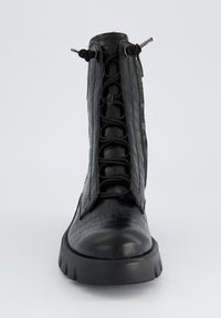 Botín negro hasta el tobillo con textura de cocodrilo, cordones en la parte delantera, punta redonda y suela gruesa. Presenta ojales de metal y cordones elásticos.