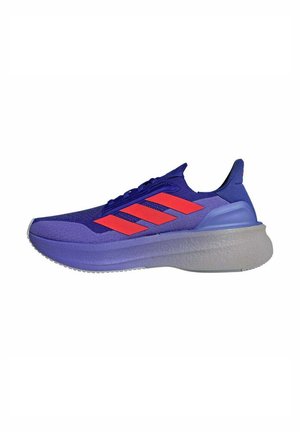 Baskets de sport violettes avec des accents bleus, dotées de trois rayures rouges sur le côté, d'une tige texturée et d'une semelle grise épaisse.