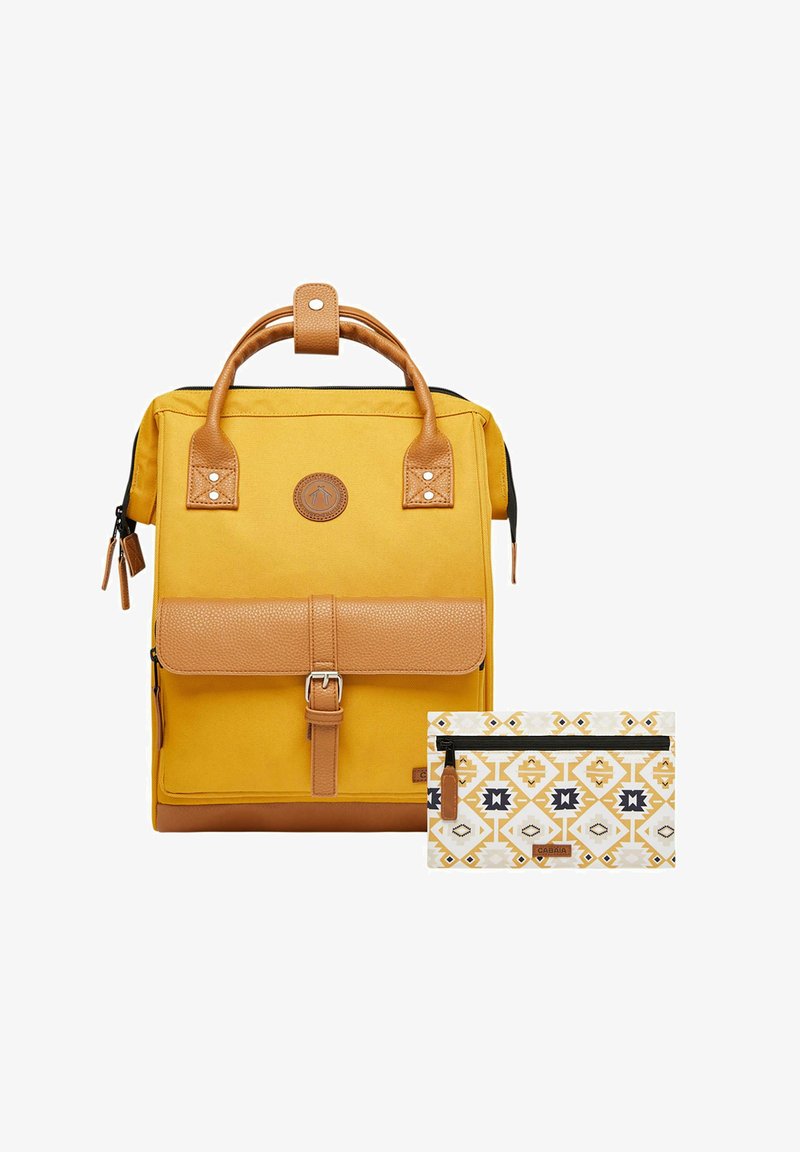 Gelber Canvas-Rucksack mit braunen Lederakzenten, einem oberen Griff und einem magnetischen Deckel. Enthält ein gemustertes weißes Täschchen mit geometrischen Designs.