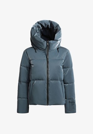 Tummansininen toppatakki, jossa on korkea taitettava kaulus, etuvetoketju ja mustat yksityiskohdat. Kaksi sivutaskua, joissa on hillitty logotarkistus.