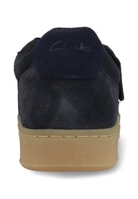 Scarpa in camoscio blu navy di Clarks con tomaia testurizzata, suola in gomma color sabbia e collare imbottito per il comfort. Cinturino in velcro per una vestibilità sicura.