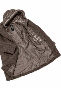 Bruine fluffy buitenstof jas met een glanzende, gladde binnenvoering. Voorzien van een capuchon en een ritssluiting. Labels zijn zichtbaar aan de binnenkant.