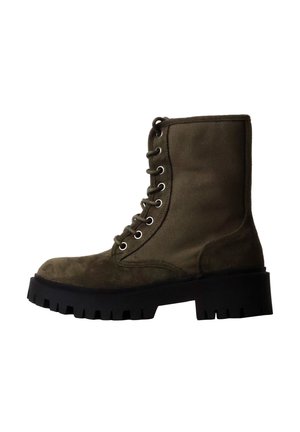 Botte de combat lacée vert olive avec semelle épaisse noire à crampons et bout renforcé, vue de profil sur fond blanc.