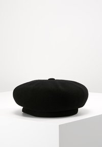 Beret de lana negra con una parte superior redondeada y plana y un pequeño botón central. Textura suave y sin patrones visibles ni herrajes adicionales.