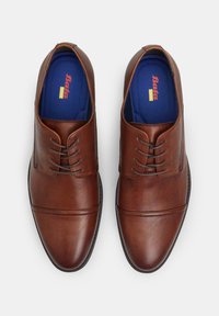Scarpe eleganti in pelle marrone con punta arrotondata, dotate di un accento cucito sopra la parte anteriore e cinque fori per i lacci. Soletta blu visibile.