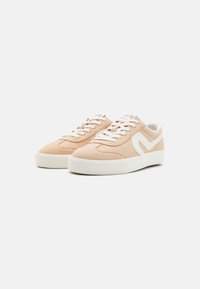 Beige ruskinn-sneakers med en hvit gummisåle, med hvite sidelogoer og snøringer. Glatt tekstur med et klassisk sporty design.