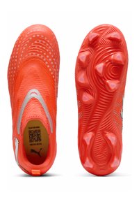 Botas de fútbol de color naranja brillante con parte superior texturizada, detalles plateados, diseño sin cordones y suela con tacos para un agarre firme en el campo.