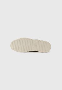 Flat beige gummisåle med horisontale riller, størrelse 42, og "Made in Italy" preget på hælområdet.