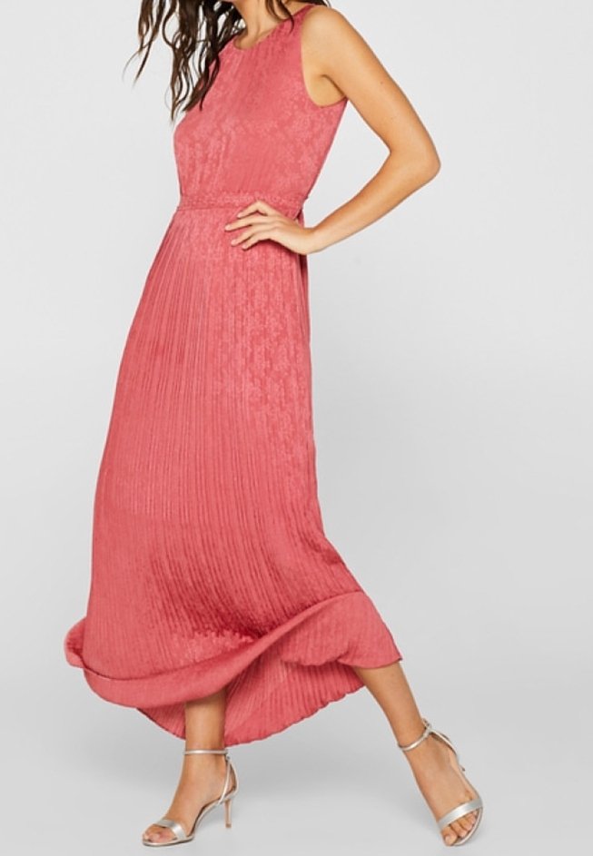 Maxi šaty z texturovaného korálu s těsným korzetem, plisovanou sukní a volným lemem. V kombinaci se stříbrnými sandály na tenkých páscích.