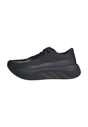 Baskets de sport noires avec semelle épaisse, design à tige basse, bande subtile texturée sur le côté et fermeture à lacets.